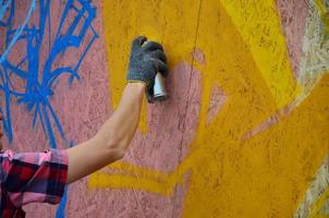 KHARKOV. UKRAINE - MAY 2, 2022 Festival of street arts. Young guys draw graffiti on portable wooden walls in the center of the city. The process of painting on walls with aerosol spray cans photo