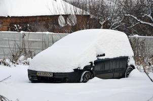 kharkov, ucrania - 4 de enero de 2022 un automóvil estacionado bajo una gruesa capa de nieve. consecuencias de una fuerte e inesperada nevada en ucrania foto