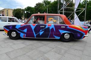 KHARKOV, UKRAINE - MAY 27, 2022 Festival of street art. A car that was painted by masters of street art during the festival. The result of the work of several graffiti artists. Original aerography photo