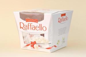 KHARKOV. UKRAINE - MAY 2, 2022 Raffaello candies on beige background. Raffaello is a spherical coconut almond confection that Italian manufacturer Ferrero brought to the market in 1990 photo