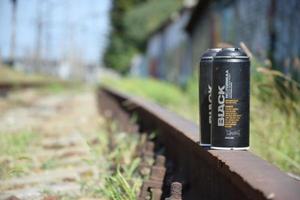 KHARKOV. UKRAINE - MAY 2, 2022 Used Montana black aerosol spray cans against graffiti paintings. MTN or Montana-cans is manufacturer of high pressure spray paint goods photo