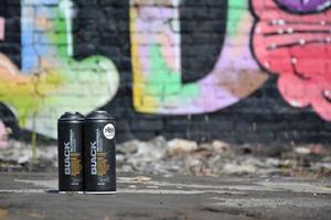 KHARKOV. UKRAINE - MAY 2, 2022 Used Montana black aerosol spray cans against graffiti paintings. MTN or Montana-cans is manufacturer of high pressure spray paint goods photo