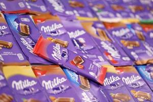 KHARKOV. UKRAINE - MAY 17, 2022 Many wrappings of purple Milka chocolate. Milka is a Swiss brand of chocolate confection manufactured by company Mondelez International photo