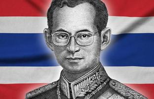 Portrait of King Bhumibol Adulyadej from 50 Baht Thailand money bill close on Thailand flag background photo