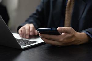 Businessman using mobile smart phone and computer laptop in modern office.Business Technology internet digital concept. photo