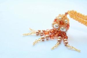 octopus made of beads and beads, orange-white-yellow, on a white background photo