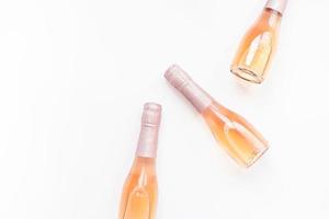 Botellas de vino de champán rosa sobre fondo blanco. foto