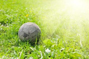 Old soccer ball on the green grass photo