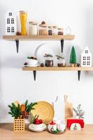 wooden kitchen shelves and part of the countertop with cans for bulk products, various cutting boards and Christmas decorations. photo