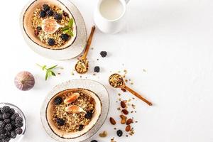 top view of the bowl with a healthy healthy breakfast of granola or muesli and ingredients for its preparation. white background. Detox. photo