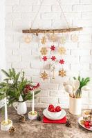 vertical view of a modern kitchen countertop decorated for the New Year and Christmas. homemade garland on a white brick wall. photo