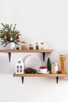 cozy comfortable interior design of open kitchen shelves decorated for the New Year and Christmas. foreground. white textured wall. photo