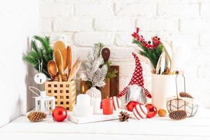 un fragmento de una encimera de cocina de madera blanca con varios artículos de cocina y adornos navideños en un estilo moderno, hechos con sus propias manos. foto