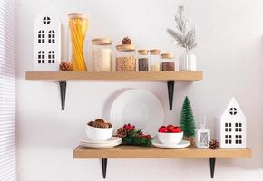 Front view of open kitchen shelves with eco jars for bulk products and Christmas decorations. cardboard white houses, natural cones. photo