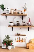 Front view of open wooden kitchen shelves and countertops with various utensils and eco decorations for the New Year. a kitchen in eco style. photo