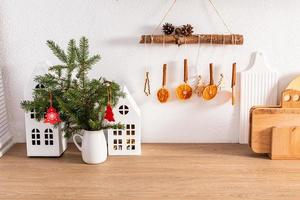 Front view part of a modern kitchen with eco-friendly items, utensils and green spruce branches.kitchen interior ideas decorated for the holiday. photo