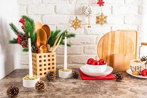 a fragment of a kitchen countertop decorated for the new year and Christmas. cozy interior of a modern kitchen. spruce branches, candles, balls.