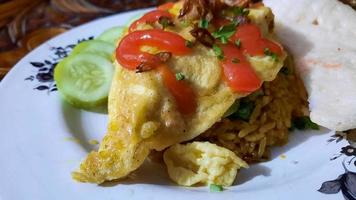 primer plano, omurice cubierto con apio, salsa y pepino como guarnición 02 foto