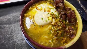 Curry-flavored instant noodles, topped with egg and fried chicken photo