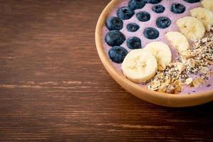 tazón de yogur o batido de yogur con bayas azules, plátano y granola foto