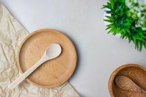 Wooden utensils on the kitchen table. Round wooden plates, a wooden spoon, a green plant. The concept of serving, cooking, cooking, interior details. Top view photo