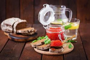 Bank with red caviar and bread photo