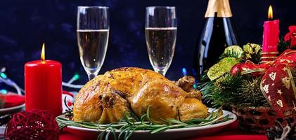 pavo al horno. cena de Navidad. la mesa navideña se sirve con un pavo, decorado con oropel brillante y velas. pollo frito, mesa. cena familiar.
