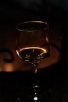 Glass of wine against the backdrop of a bonfire in the fireplace photo