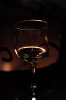 Glass of wine against the backdrop of a bonfire in the fireplace photo