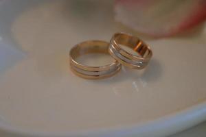 Wedding rings on a white saucer photo