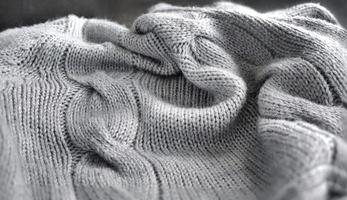 Selective focus Knitted Woolen, Knitwear Fabric Texture, Warm Clothes for Fall and Winter, Woven, Woolen, Sweaters, gray color with Dark Background and copy space photo