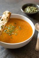 Pumpkin Soup in a Bowl with Bread Sticks photo