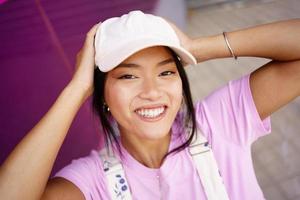Asian woman touching head and smiling photo