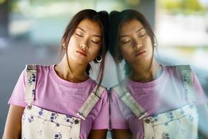 Asian woman near glass wall photo