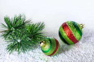 Spruce branch, Christmas balls shiny, green in the snow. Christmas decorations photo