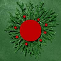 A mock-up of green branches with a red paper card for the inscription. New Year and Christmas. Top view photo