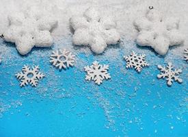 Christmas background. White decorations Christmas balls and snowflakes on soft snow, copy space, place for text photo