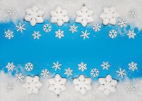 Christmas background. White decorations Christmas balls and snowflakes on soft snow, copy space, place for text photo