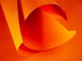 Colored paper rolled up. Abstract bright orange paper background for your design. Selected sharpness. photo