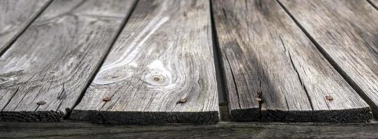 An old cracked board with rusty nails in close-up. Wooden grunge background. Textured background with space for text photo