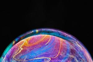 Virtual reality space with abstract multicolor psychedelic planet. Closeup Soap bubble like an alien planet on black background. photo