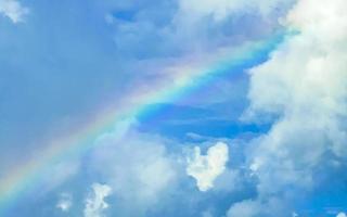 hermoso y raro arco iris en el fondo azul cielo nublado méxico. foto