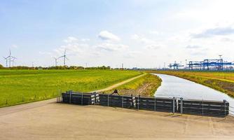 Industrial area cranes container dyke seascape panorama in Imsum Germany. photo