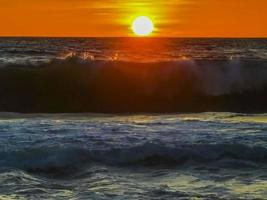 Colorful golden sunset big wave and beach Puerto Escondido Mexico. photo