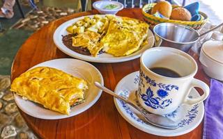 Mexican omelet with black beans potatoes nachos on white plate. photo