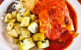 Mexican omelet with black beans potatoes nachos on white plate. photo