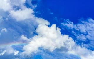 Beautiful and rare rainbow in cloudy sky blue background Mexico. photo