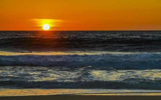 colorido atardecer dorado gran ola y playa puerto escondido mexico. foto