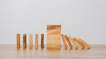 Business Risks and Strategies. Stopping Wood Block Domino. Business Crisis Impact or hedging concept, Prevention and development towards security. photo