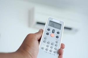 Close up of man hand holding air condition remote. photo